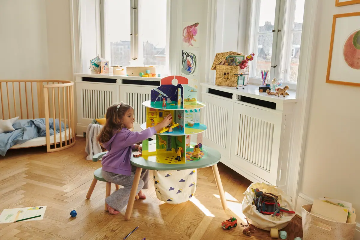 เด็กหญิงเล่นบ้านตุ๊กตา MuTable Playhouse บนโต๊ะ