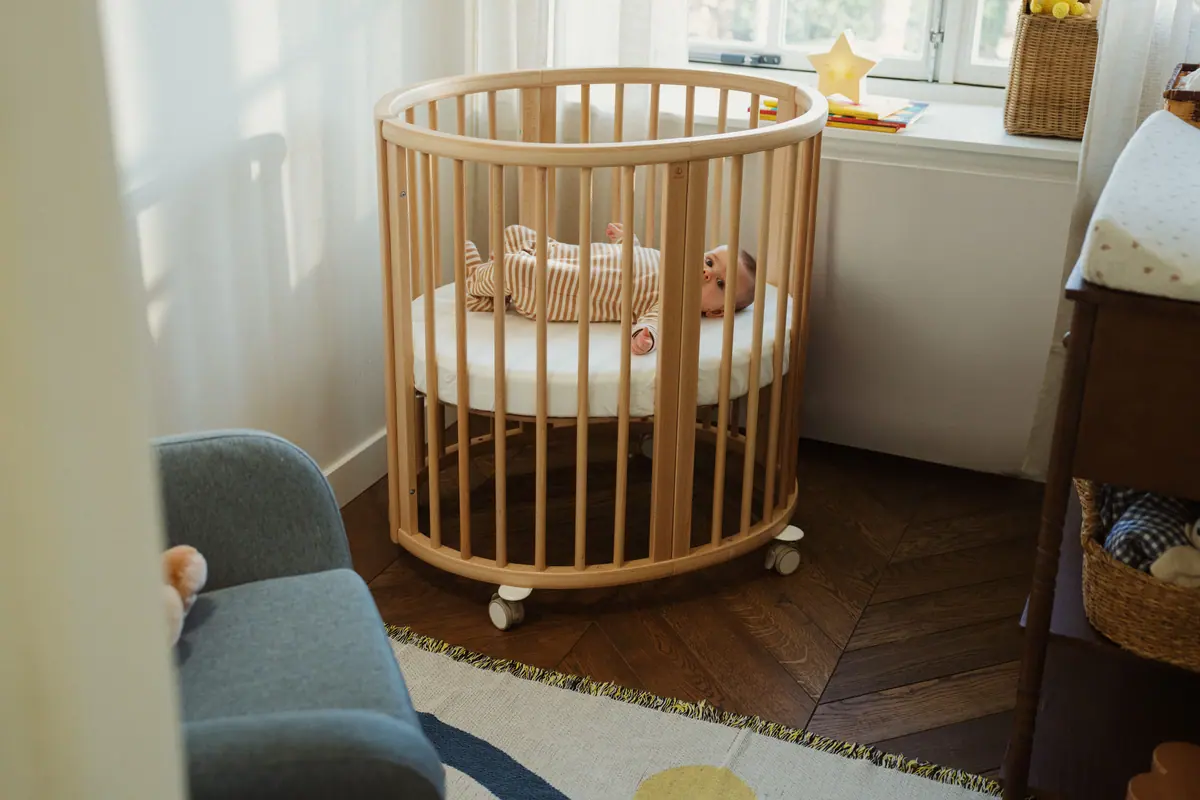ลูกแรกเกิดนอนในเตียง Sleepi Mini ในมุมห้องนอนที่เงียบสงบ
