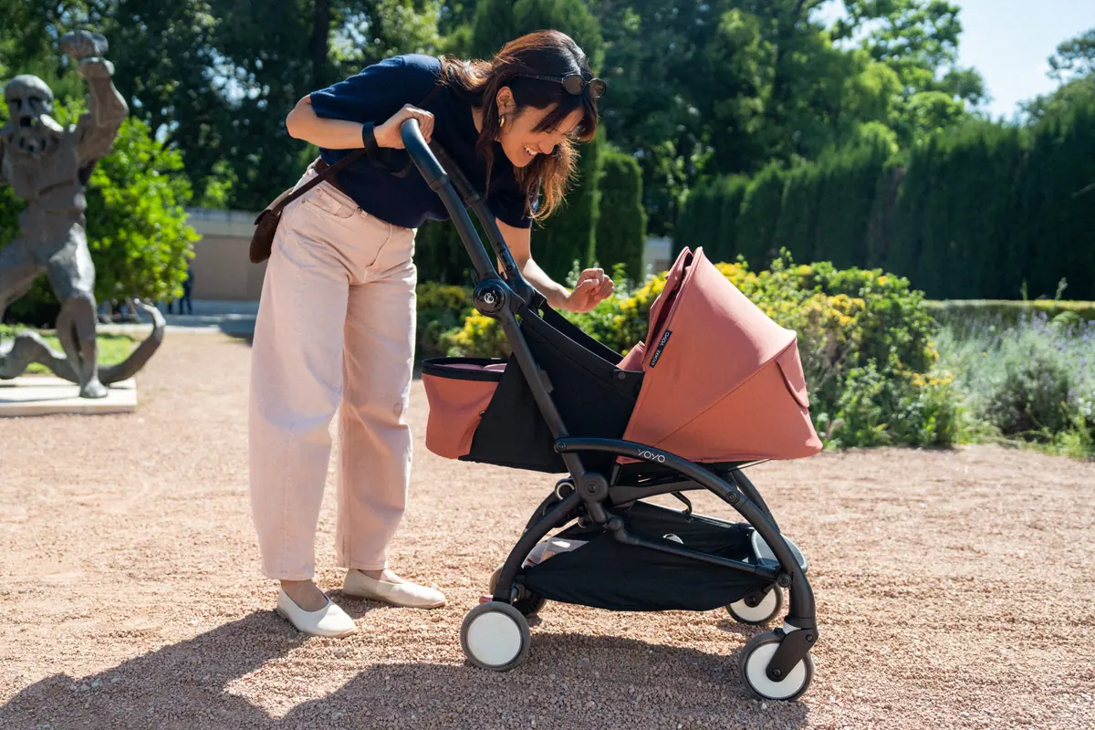 คุณแม่ก้มดูลูกแรกเกิดใน YOYO5 Newborn Pack ในสวนกลางแดด