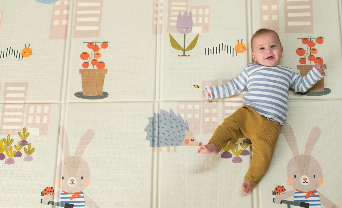ทารกหัวเราะนอนบนแผ่นรองคลานโฟมลายสวน Taf Toys